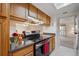 Galley kitchen featuring wooden cabinets, modern stainless steel appliances, and views to other rooms at 12108 Melody Dr # 103, Denver, CO 80234