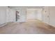 Bright living room featuring neutral carpet, white walls, and pass through to adjacent kitchen at 12108 Melody Dr # 103, Denver, CO 80234