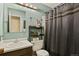 Bathroom featuring a sink, toilet, shower curtain, and open storage shelf for supplies at 5030 Titan Ct, Denver, CO 80239