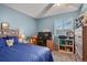 A blue bedroom with a large window and a desk with computer setup at 5030 Titan Ct, Denver, CO 80239