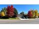A beautiful single-story home with a lawn, fall foliage, an attached garage, and a concrete driveway at 5030 Titan Ct, Denver, CO 80239