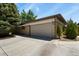 The garage of this home has space for two cars with a large concrete driveway and a brick and siding exterior at 5030 Titan Ct, Denver, CO 80239