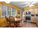 Eat-in kitchen with stainless steel microwave and stove, light wood cabinets, and a table with four wooden chairs at 5030 Titan Ct, Denver, CO 80239