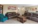 The comfortable living room has plush carpet, a leather sofa and chair, plus a wooden coffee table and side table at 5030 Titan Ct, Denver, CO 80239