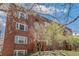 Brick apartment building featuring a green entrance and mature trees at 1416 N Downing St # 1, Denver, CO 80218