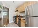 Kitchen with stainless steel refrigerator, light wood cabinets, gas range, and dishwasher at 1416 N Downing St # 1, Denver, CO 80218