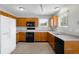 Well-lit kitchen featuring wood cabinets, essential appliances, and tile flooring at 4127 S Lewiston Cir, Aurora, CO 80013