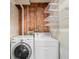 Functional laundry area with modern washer, dryer, and shelving for organized storage at 4127 S Lewiston Cir, Aurora, CO 80013