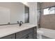 Modern bathroom with gray tile, quartz counters, and bathtub at 461 Muirfield Cir, Louisville, CO 80027