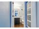 A bright and clean bathroom with blue accent walls, a modern vanity, and a storage cabinet at 11898 W Tufts Pl, Morrison, CO 80465