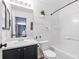 A full bathroom with dark wood cabinets, white sink, and shower-tub combination at 11898 W Tufts Pl, Morrison, CO 80465