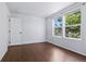 A bedroom with hard wood floors and a window view of lush, mature trees at 11898 W Tufts Pl, Morrison, CO 80465