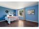 A bright bedroom with blue walls, hard wood floors and decor accents at 11898 W Tufts Pl, Morrison, CO 80465