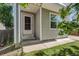 Entrance of the gray home featuring a storm door, white pillars, and a well-maintained lawn at 11898 W Tufts Pl, Morrison, CO 80465