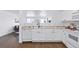 Bright kitchen featuring white cabinetry, modern appliances, and hardwood floors with a view of the living space at 11898 W Tufts Pl, Morrison, CO 80465