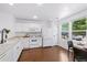 Bright kitchen with modern appliances, white cabinetry, hardwood floors, and a dining area by the window at 11898 W Tufts Pl, Morrison, CO 80465