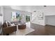 Bright living room with hardwood floors, a modern sofa, and large windows offering natural light at 11898 W Tufts Pl, Morrison, CO 80465