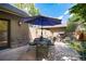 Relaxing patio featuring a large table with chairs, stone fireplace, and lush landscaping at 2042 S Clayton St, Denver, CO 80210