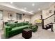 Basement living area featuring a green sofa, stairs, and Simpsons pinball machine at 2042 S Clayton St, Denver, CO 80210
