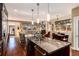 Open-concept kitchen with granite island, stainless steel sink, and views of the living and dining areas at 2042 S Clayton St, Denver, CO 80210