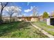 The backyard of a brick single-story house with a walkway and plenty of green space at 256 King St, Denver, CO 80219
