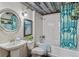Bathroom featuring tub with shower, toilet and pedestal sink with silver framed mirror at 1111 Osage St # 29, Denver, CO 80204