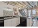 Bright kitchen with modern appliances, black countertops, stairs, and exposed brick wall at 1111 Osage St # 29, Denver, CO 80204