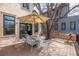 View of a backyard deck with an umbrella, table, chairs and access to the house through French doors at 2673 S Cook St, Denver, CO 80210