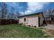 A beautiful backyard with lush grass, and an detached unit with green trim and a green door at 2673 S Cook St, Denver, CO 80210