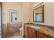 Well-lit bathroom with wood cabinets, granite countertop, and a decorative mirror at 2673 S Cook St, Denver, CO 80210