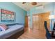 Bedroom with hardwood floors, ceiling fan and a closet with stained wood doors at 2673 S Cook St, Denver, CO 80210
