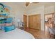 Bright bedroom with hardwood floors, closet with stained wood doors and access to the kitchen at 2673 S Cook St, Denver, CO 80210