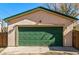 A detached garage features a green door that matches the trim of the home at 2673 S Cook St, Denver, CO 80210