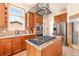 Gourmet kitchen boasts stainless steel appliances, a center island with cooktop, and custom cabinets at 2673 S Cook St, Denver, CO 80210