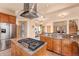 Open kitchen featuring custom cabinets, granite countertops, stainless steel appliances and a center island with cooktop at 2673 S Cook St, Denver, CO 80210