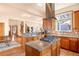 Bright and spacious kitchen features stainless appliances, custom cabinets, a center island with cooktop and access to the rest of the house at 2673 S Cook St, Denver, CO 80210