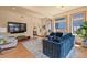 Bright living room featuring hardwood floors, a blue sofa, and large windows for ample natural light at 2673 S Cook St, Denver, CO 80210