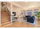 Spacious living room with a staircase, hardwood floors, and a large window overlooking the backyard at 2673 S Cook St, Denver, CO 80210