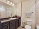 Bathroom with dark vanity, a large mirror, tiled shower, and modern fixtures at 12856 Jasmine St # E, Thornton, CO 80602