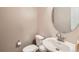 Cozy bathroom with a modern sink, toilet and round mirror at 12856 Jasmine St # E, Thornton, CO 80602
