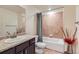 Bathroom features a shower-over-tub combination, tile accents, and vanity with granite countertops at 12856 Jasmine St # E, Thornton, CO 80602