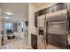 Open-concept view of kitchen flowing into living area, featuring stainless steel refrigerator at 12856 Jasmine St # E, Thornton, CO 80602