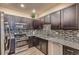 Modern kitchen features stainless steel appliances, granite countertops, and dark wood cabinets at 12856 Jasmine St # E, Thornton, CO 80602