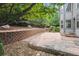 Beautifully landscaped backyard with a stone patio, retaining wall, and mature trees for privacy at 10440 Lowell Ct, Westminster, CO 80031