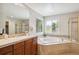 Bathroom with a large soaking tub, a large mirror, and a separate shower area at 10440 Lowell Ct, Westminster, CO 80031