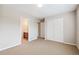 Bedroom with tan carpet, a closet with sliding doors and open doorway to the bathroom at 10440 Lowell Ct, Westminster, CO 80031