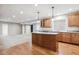 Open basement kitchen with wood cabinets, modern pendant lights, and an adjacent living area at 10440 Lowell Ct, Westminster, CO 80031