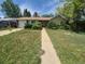 Charming single-story home with well-placed shrubs accenting the exterior and a walkway to the front door at 867 S Grape St, Denver, CO 80246