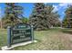 The entry sign for Judge Joseph E. Cook Park, a Denver park with lush greenery and tall trees at 5300 E Cherry Creek South Dr # 1327, Denver, CO 80246
