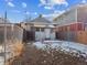 Backyard with partial snow cover, with fenced yard and small house at 805 S Lincoln St, Denver, CO 80209